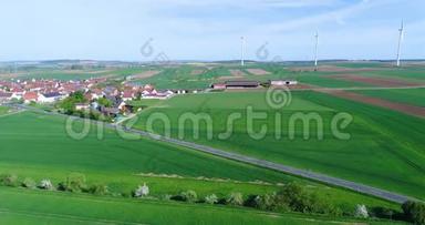 在现代欧洲的一个小村庄附近飞行，在风力发电机附近飞行，在风力发电机的背景下飞行